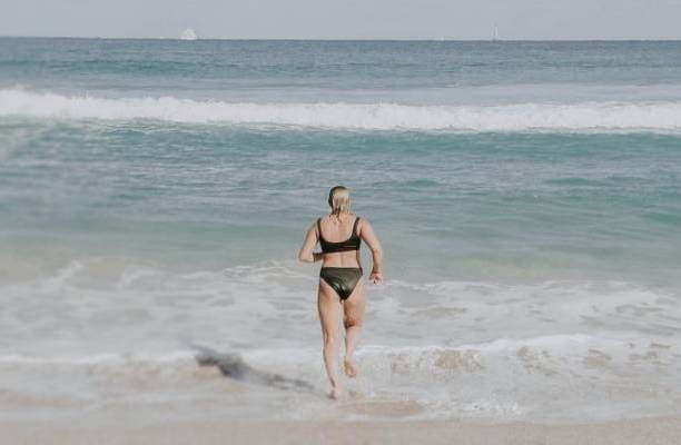 lady at beach running into water after weight loss from stomach gastric balloon
